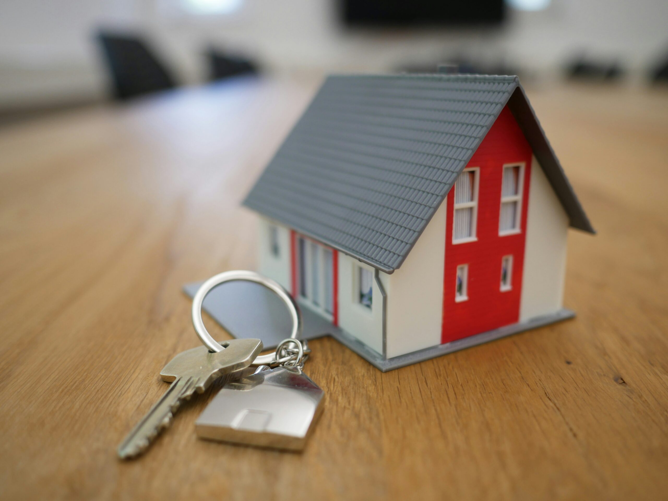Red and white wooden house miniature on a brown table.